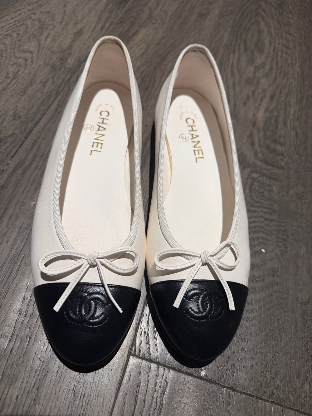 CHANEL White Leather Ballet Flats with Black Cap Toe and Bow